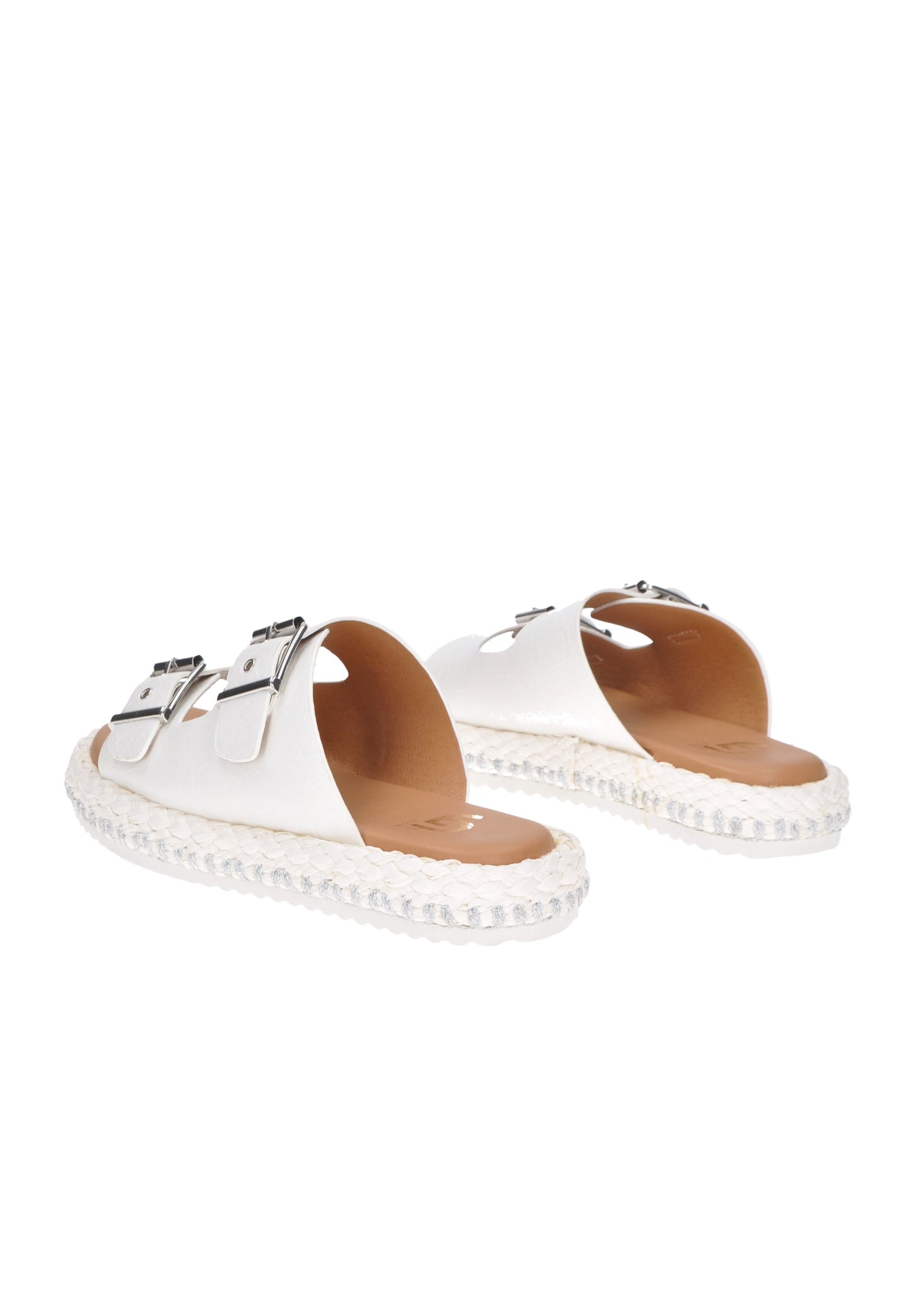White slip-on sandals with double buckle design and braided sole for stylish comfort.