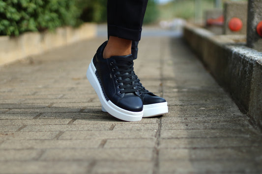 acquisto scarpe da uomo ideali: scarpe nere con suola bianca su un vialetto
