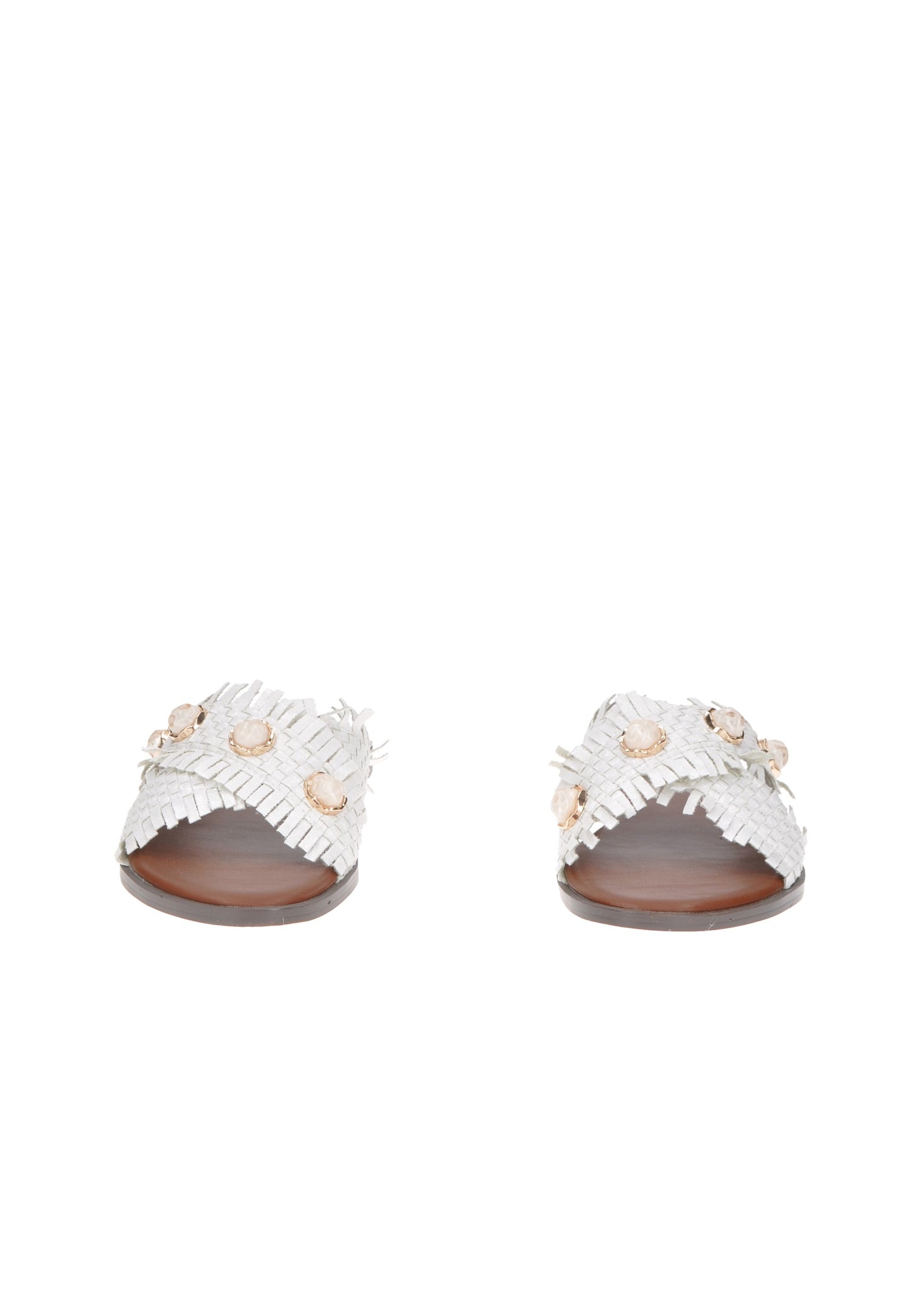 Stylish white sandals with ruffled design and decorative embellishments on a wooden background.