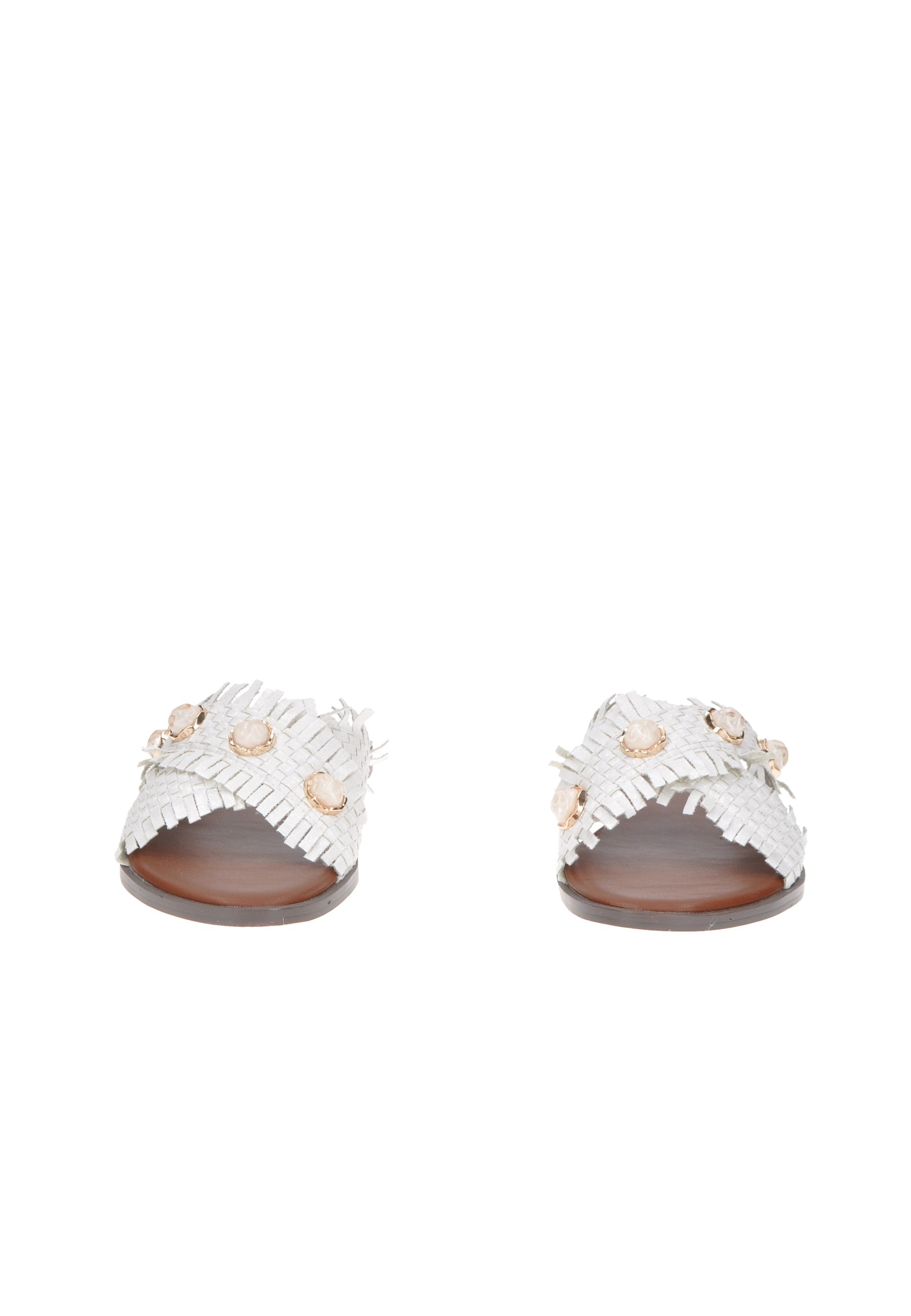 Stylish white sandals with ruffled design and decorative embellishments on a wooden background.